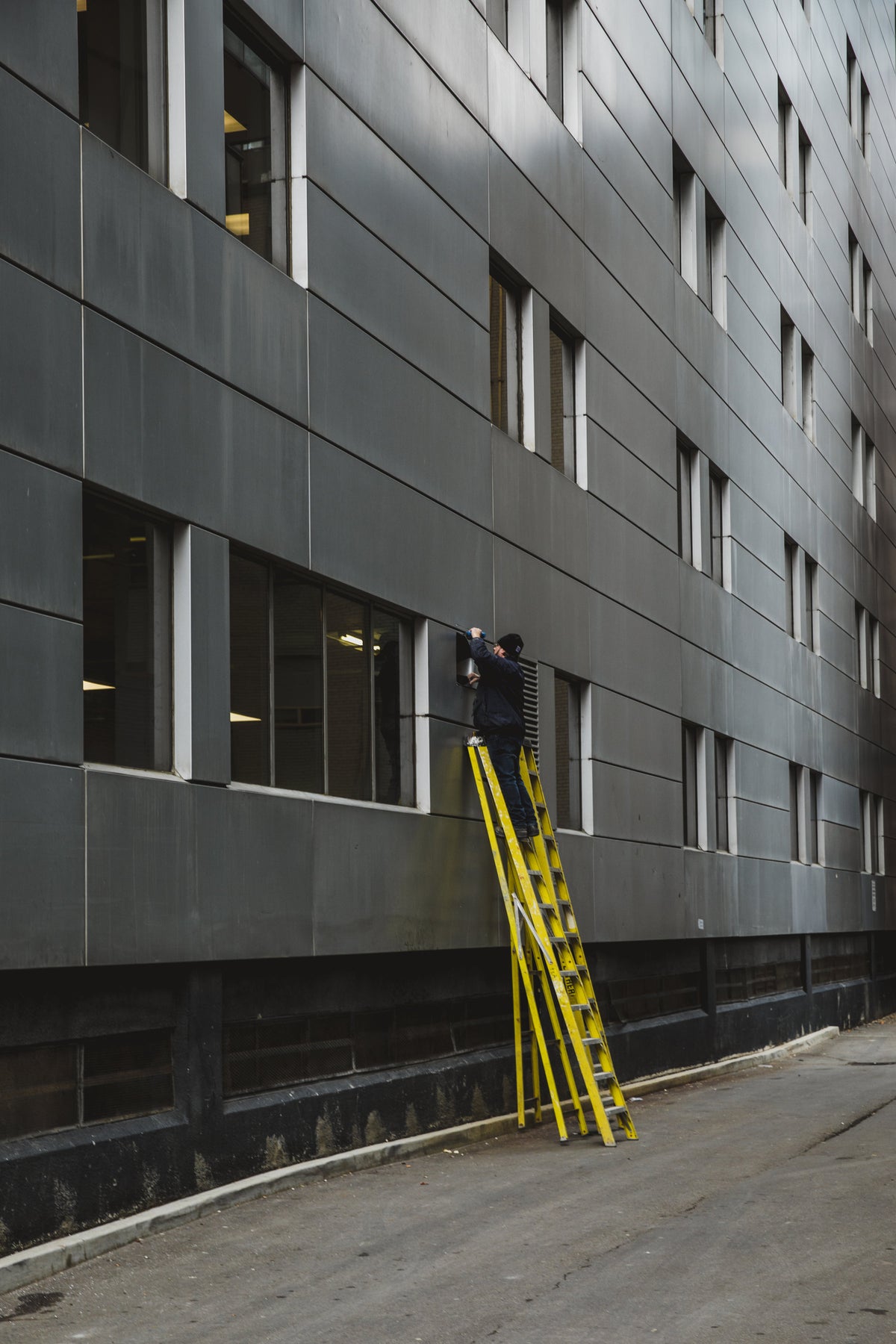 Personne sur une échelle contre une façade