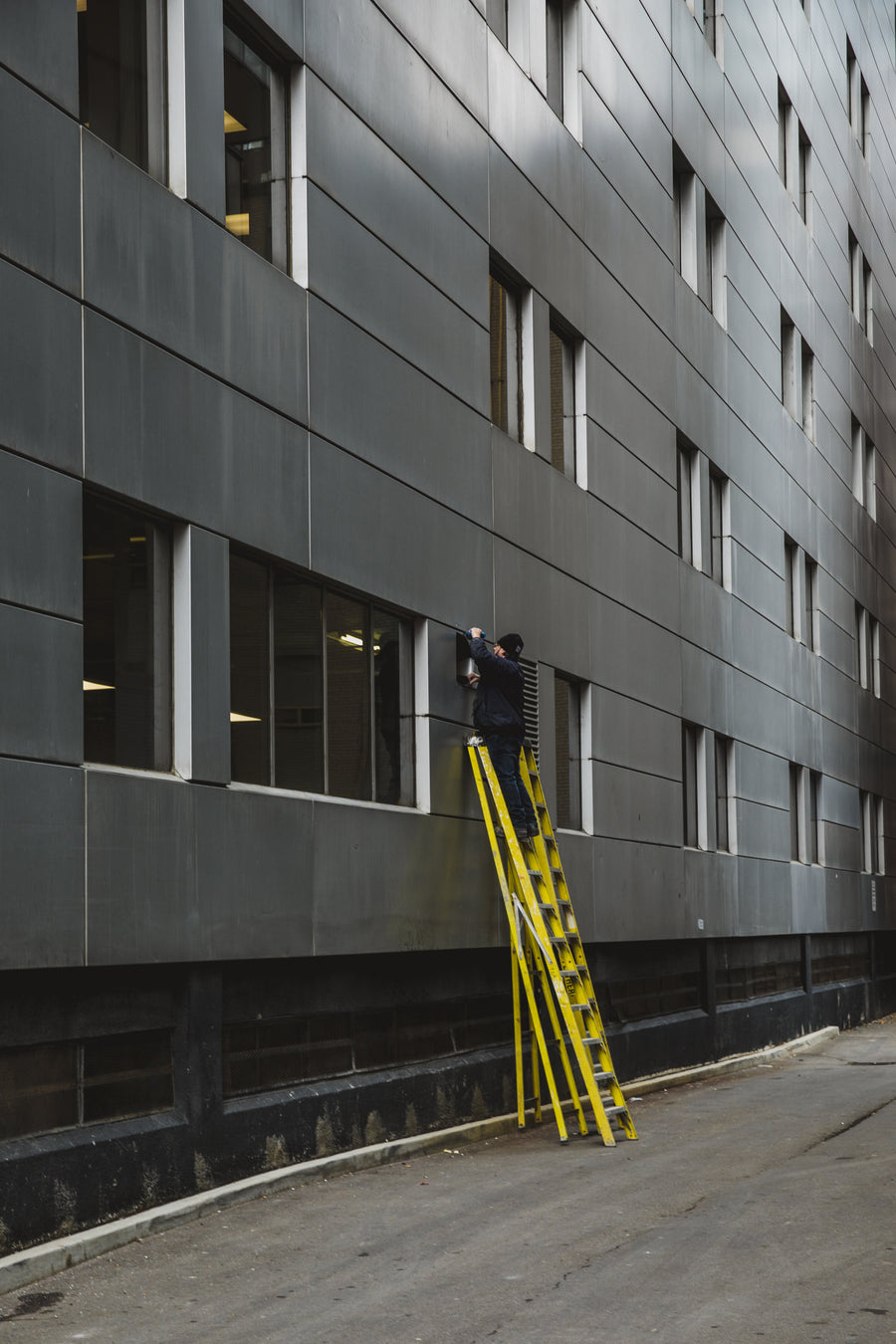 Personne sur une échelle contre une façade