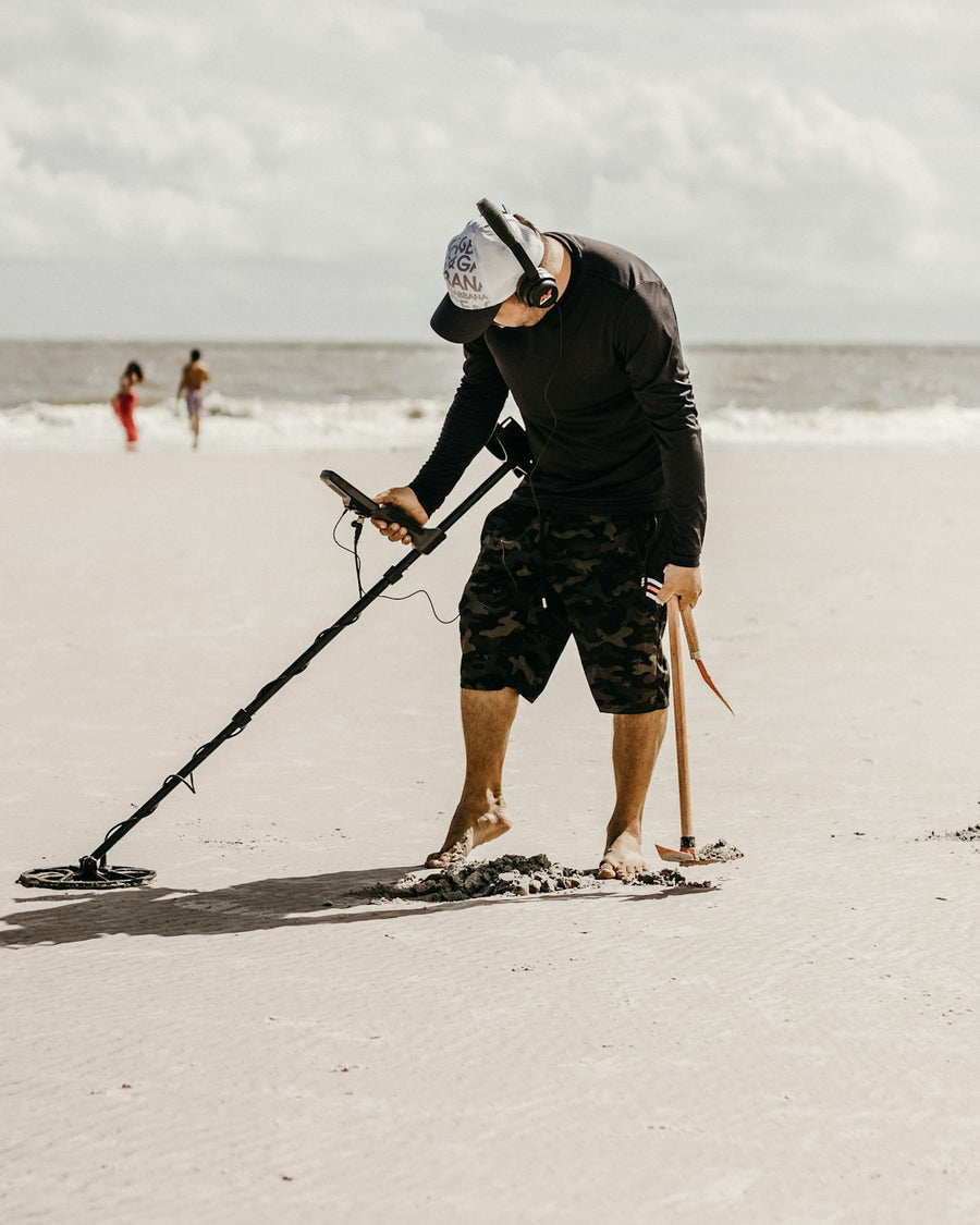 Prospection au détecteur de métaux sur une plage de sable